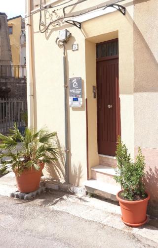 a house with two potted plants in front of a door at GUEST HOUSE PIANA DEGLI ALBANESI in Piana degli Albanesi