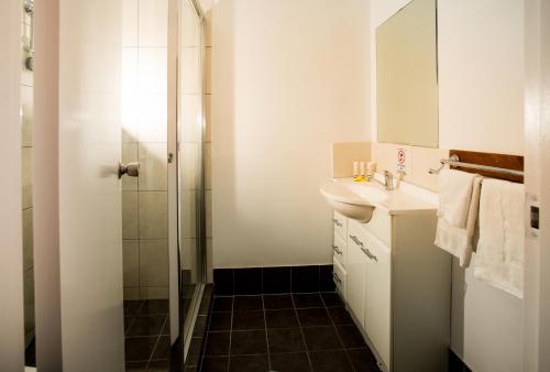 a white bathroom with a sink and a shower at De Lago Resort On Lake Bennett in Lake Bennett