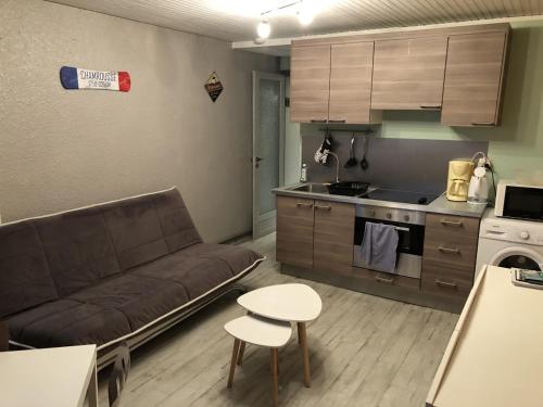 un salon avec un canapé et une cuisine dans l'établissement Appartement 5 Personnes au pied des pistes - WIFI -, à Chamrousse