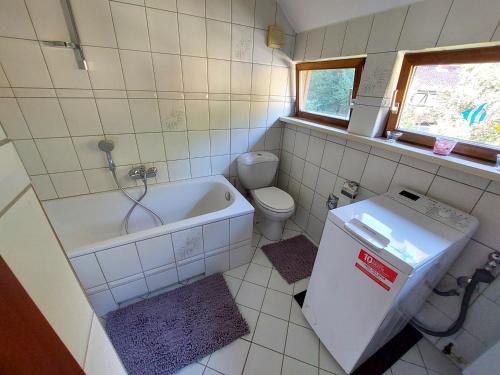 a bathroom with a tub and a toilet and a sink at Gemütliche Ferienwohnung im Harz in Bad Grund