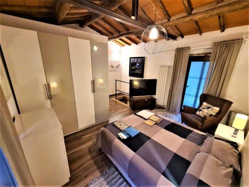 ein Schlafzimmer mit einem großen Bett und ein Wohnzimmer in der Unterkunft Incantevole casa sul fiume, Relax e Natura ai piedi della Alpi Apuane in Massa
