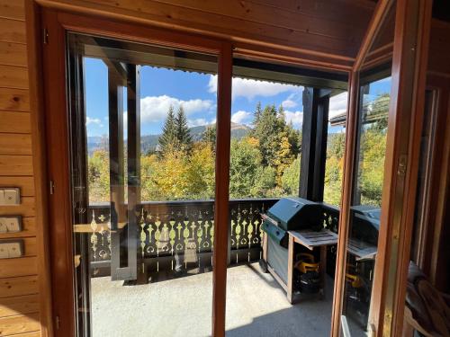 a room with a balcony with a view of the mountains at Le Chalet de Nabor in Les Gets