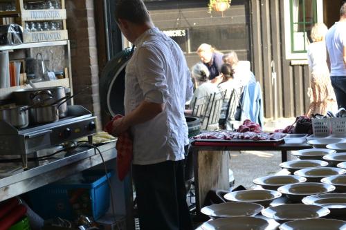 a man standing in a kitchen preparing food at lodge 61 hotel aan het water in Medemblik
