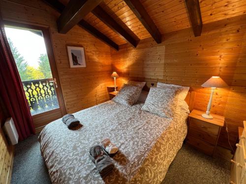 um quarto com uma cama num chalé de madeira em Le Chalet de Nabor em Les Gets