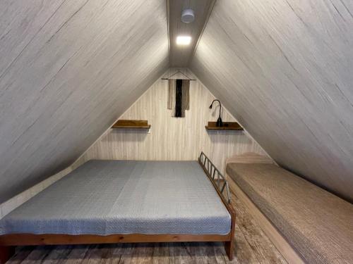 a bed in a tiny house with a roof at Poilsis Preiloje-91 in Neringa