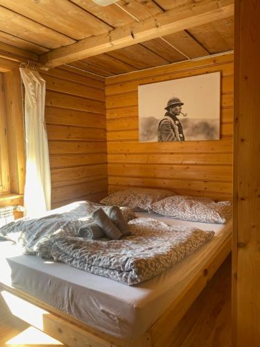 a man laying on a bed in a wooden room at Hostel Regionalny in Zakopane