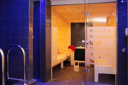 a bathroom with a shower with a sign on the door at Familotel Amiamo in Zell am See