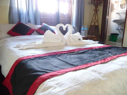 two swansuitsrendered to look like swans on a bed at HOTEL RUPAKOT AND ROOFTOP RESTAURANT in Bhaktapur