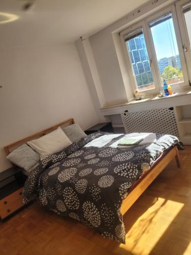 sypialnia z łóżkiem w pokoju z oknami w obiekcie SilverSky Apartment w Warszawie