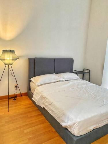 a bed in a room with a lamp and a bed sidx sidx sidx at Setia Alam @ SCCC 3 Storey House in Shah Alam