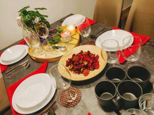 a table with plates of food and wine glasses at Setia Alam @ SCCC 3 Storey House in Shah Alam