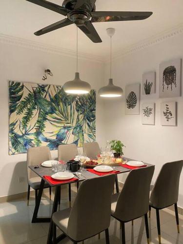 a dining room with a table with chairs and a ceiling fan at Setia Alam @ SCCC 3 Storey House in Shah Alam