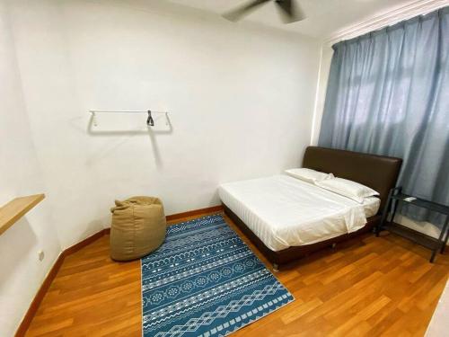 a small bedroom with a bed and a rug at Setia Alam @ SCCC 3 Storey House in Shah Alam