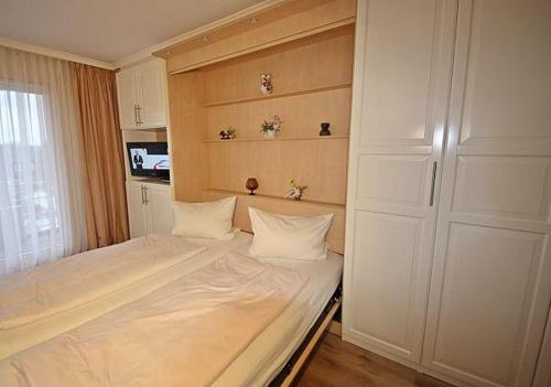 Un dormitorio con una cama con dos almohadas encima. en Haus Norderhoog Wohnung 54, en Westerland