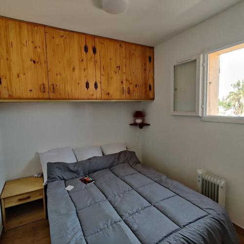 - une chambre avec un grand lit et une armoire en bois dans l'établissement Appartement cosy proche port, plages et montagnes., à Saint-Cyprien