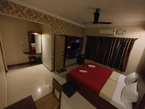 a hotel room with a bed and a television at Vyavahar lodge in Udupi
