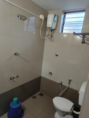 a bathroom with a toilet and a shower at Vyavahar lodge in Udupi