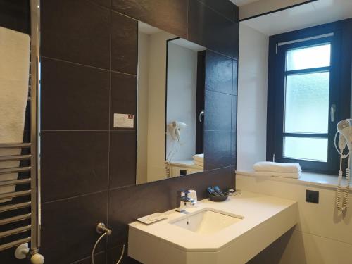 a bathroom with a sink and a mirror at Hotel Villa Marrón in Naves