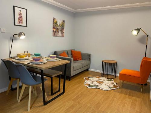 uma sala de estar com uma mesa e um sofá em Private Main Door Lovely 2 bedroom apartment em Edimburgo