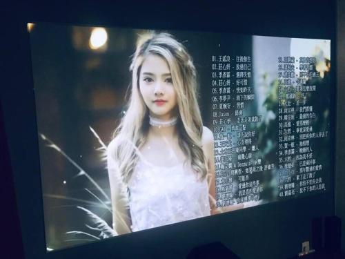 a television screen with a picture of a woman at 3 Storey Swimming Pool&Projector House Setia Alam in Shah Alam