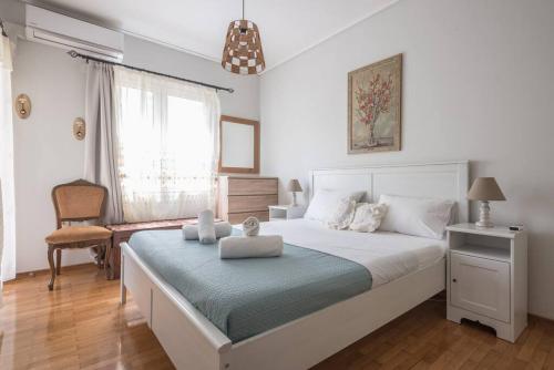 - une chambre avec un grand lit blanc et une chaise dans l'établissement Seaside 2BR apartment in Varkiza 2mins walk from beach, à Vari