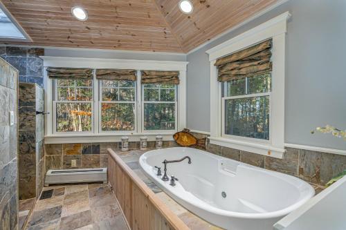 Meredith's Place في ميريديث: حمام كبير مع حوض استحمام ونوافذ
