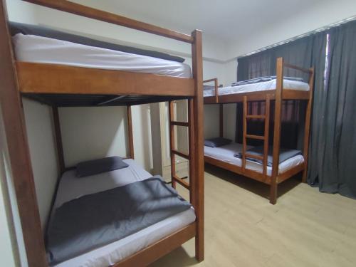 two bunk beds in a room with another bed at Step-in Lodge in Kota Kinabalu