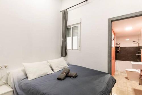 a bedroom with a bed with two pairs of shoes on it at Apartamento en planta baja en badalona, barcelona in Badalona