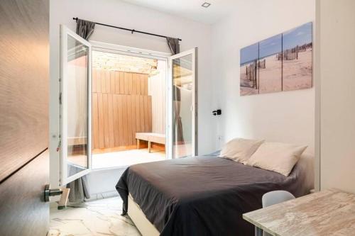 Schlafzimmer mit einem Bett und einer Glasschiebetür in der Unterkunft Apartamento en Planta Baja en Badalona in Badalona