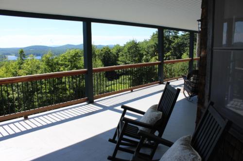 a balcony with two chairs and a view of the mountains at Clear Skies in Holderness