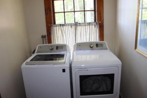 a kitchen with a stove and a washing machine at Clear Skies in Holderness