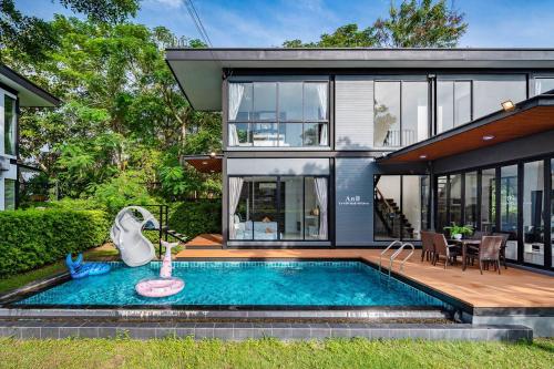 a house with a swimming pool in front of a house at AnB Loft poolvilla 3BR/3bath close Jomtian beach in Ban Huai Yai