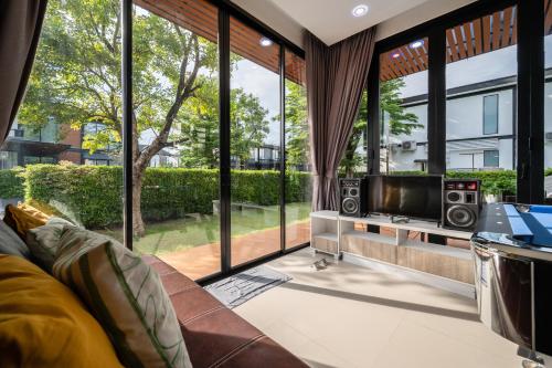 a living room with a couch and large windows at AnB Loft poolvilla 3BR/3bath close Jomtian beach in Ban Huai Yai
