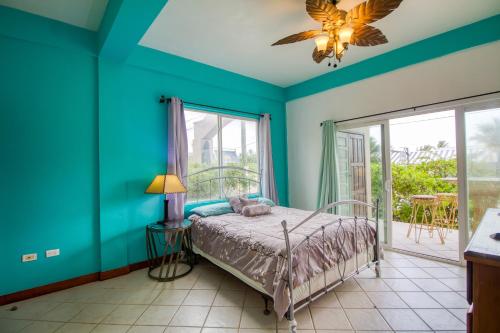 1 dormitorio con paredes azules, 1 cama y ventana en Suite E101 at Mara Laguna Gold Standard Certified, en San Pedro