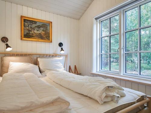 NeksøにあるHoliday home Nexø XLIの大きなベッド1台(窓2つ付)が備わるベッドルームです。