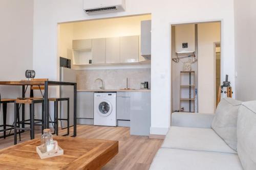 un salon avec un canapé blanc et une table dans l'établissement Magnolia magnifique T2 entièrement rénové., à Montauban