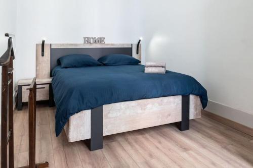 een slaapkamer met een bed met een blauw dekbed bij Magnolia magnifique T2 entièrement rénové. in Montauban