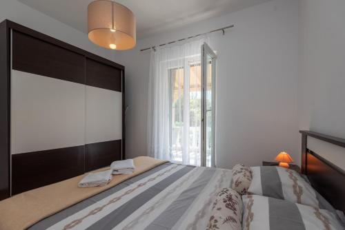 a bedroom with a bed with a large window at Apartman Tribunj in Tribunj