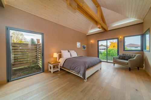 1 dormitorio con cama, sofá y ventanas en Dream 5BD Villa for Families - Geneva Centre 14KM by GuestLee, en Veigy-Foncenex