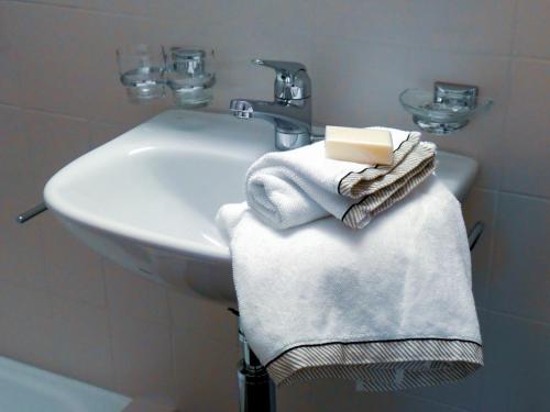 ein Badezimmer mit einem weißen Waschbecken und Handtüchern in der Unterkunft Hotel-Restaurant Rosenburg in Wolfhausen