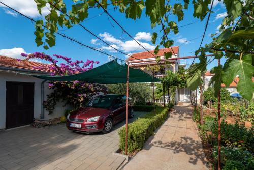 a car parked in the driveway of a house at Apartman Tribunj in Tribunj