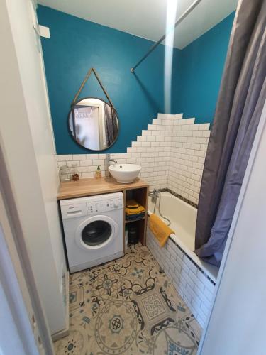 een badkamer met een wasmachine en een wastafel bij Belle vue à 500m des thermes - climatisé in Royat
