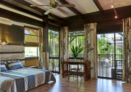 a bedroom with a large bed and large windows at Chaykovski Boutique H in Las Terrenas