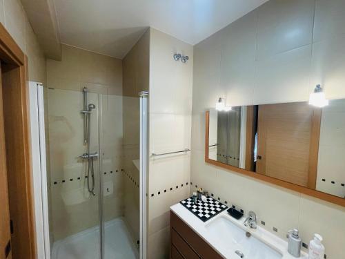 uma casa de banho com uma cabina de duche em vidro e um lavatório. em Conforto em Fátima em Fátima