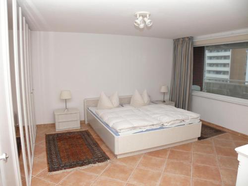 a bedroom with a white bed and a window at Haus Nordseeresidenz Wohnung 71 in Westerland