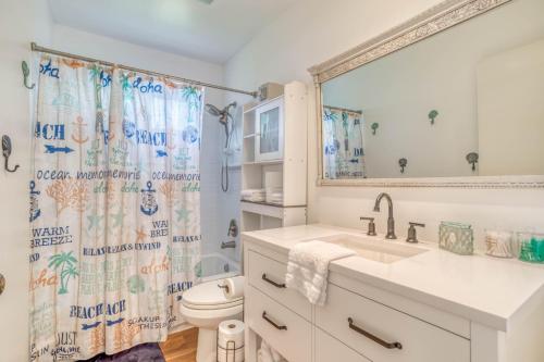 a bathroom with a sink and a toilet and a shower curtain at Lincoln House in Lincoln City