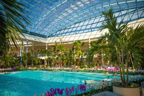 a large pool in a building with people swimming in it at Suntago Village - Oficjalny nocleg Suntago in Mszczonów
