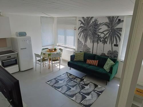a living room with a green couch and a table at Casa Roman - nieuwe vakantiewoning - Deluxe 4p - Relax 4p - Comfort 4p -- ---Cosy 2p in Zonhoven