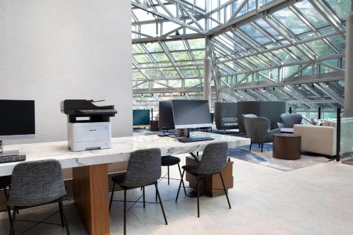 an office with a desk with a piano and chairs at Crowne Plaza Atlanta Perimeter at Ravinia by IHG in Atlanta