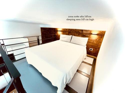 una piccola camera da letto con un letto con lenzuola bianche di Apartment Typex a Milano